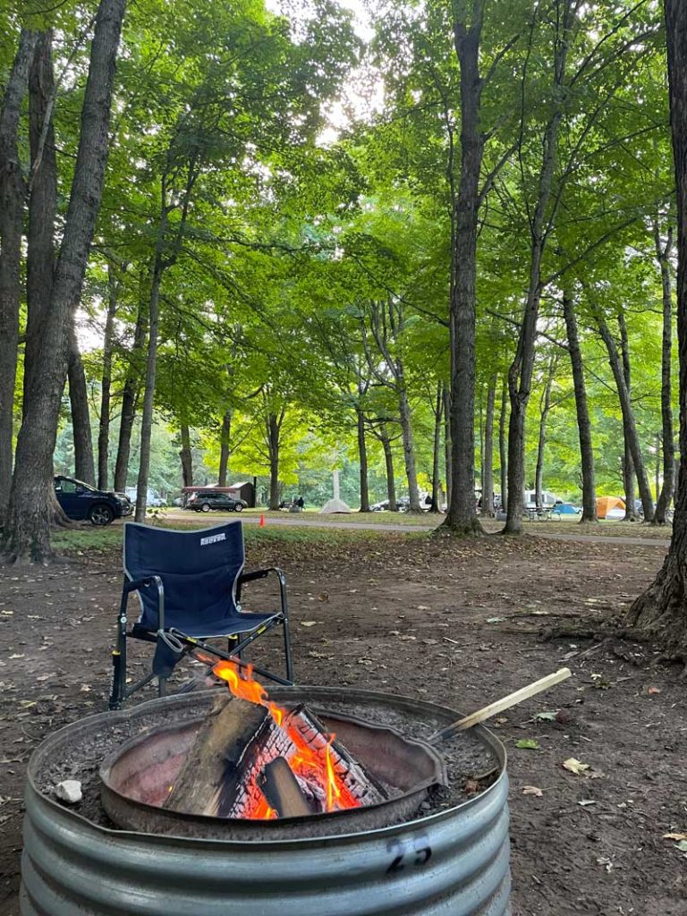 Camping chair in front of campfire in camp site